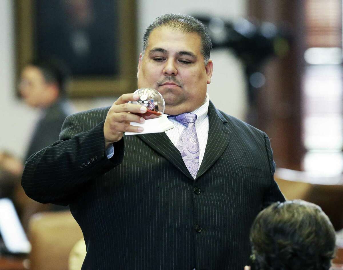 Representative Ryan Guillen, D-Rio Grande City, looks into an ornamental bulb before property tax legislation is considered on the floor of the House at the Texas Capitol on May 18, 2017.