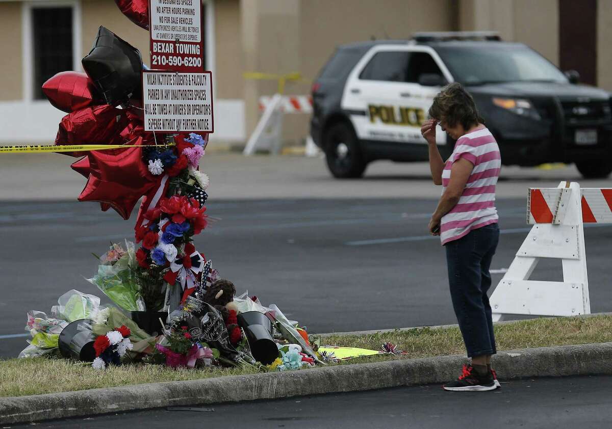 A mourner prays near a memorial as fire investigators remain at the scene of a four-alarm fire that took the life of SAFD firefighter Scott Deem. On Saturday, May 20, 2017, the scene at the Ingram Square retail center was still heavily blocked off as investigators examine remnants of a structure fire so intense that it resulted in the death of the six-year veteran of the fire department. A few mourners came to pray at a small memorial built near the scene. (Kin Man Hui/San Antonio Express-News)