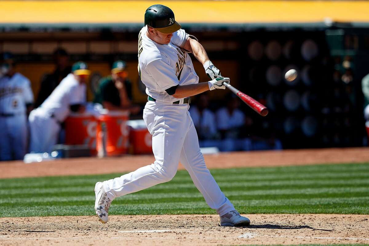 OAKLAND, CA - MAY 20: Mark Canha #20 of the Oakland Athletics hits a home run against the Boston Red Sox during the fifth inning at the Oakland Coliseum on May 20, 2017 in Oakland, California. The Oakland Athletics defeated the Boston Red Sox 8-3. (Photo by Jason O. Watson/Getty Images)