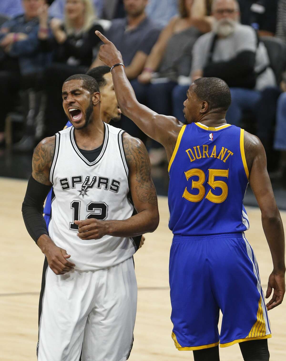 San Antonio Spurs forward LaMarcus Aldridge(12) reacts after missing a shot as Golden State Warriors forward Kevin Durant (35) gestures during the first half in Game 3 of the NBA basketball Western Conference finals on Saturday, May 20, 2017, in San Antonio. (AP Photo/Ronald Cortes)