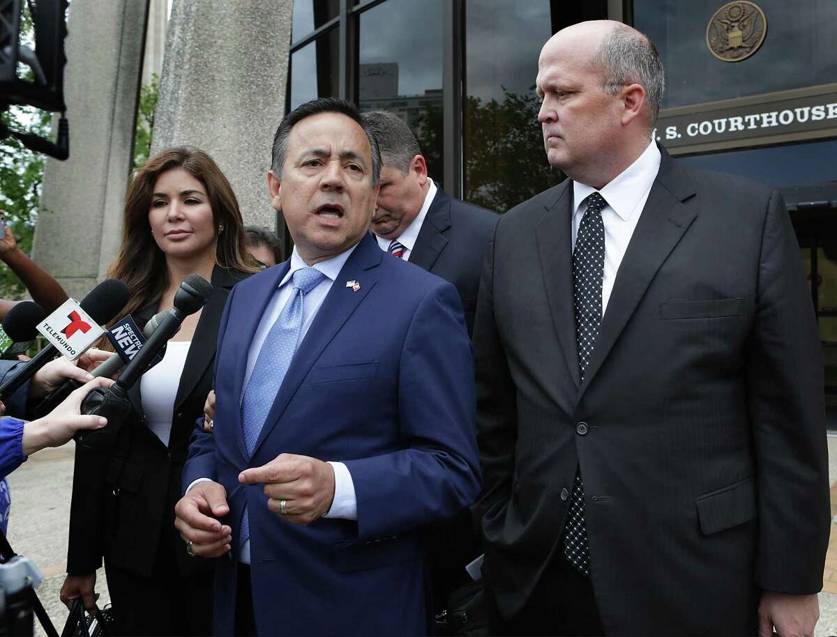 State Sen. Carlos Uresti, center, with his wife, Lleanna, and his lawyer Mikal Watts, speaks to the media on May 17 outside the San Antonio federal courthouse following an initial appearance in his criminal case. Uresti has pleaded not guilty to 13 charges in two indictments.