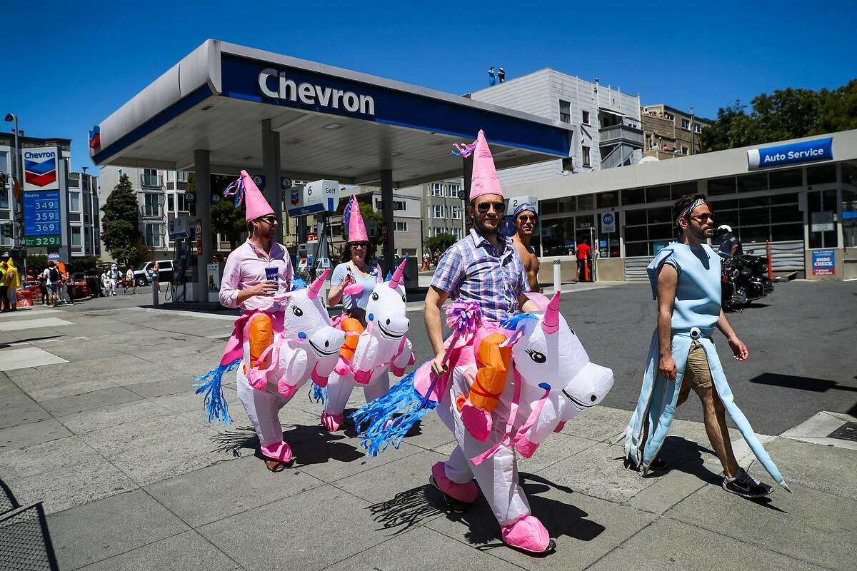 People dressed as unicorns walk on Fell Street as they participate in the Bay to Breakers annual race in San Francisco, California, on Sunday, May 21,2017.