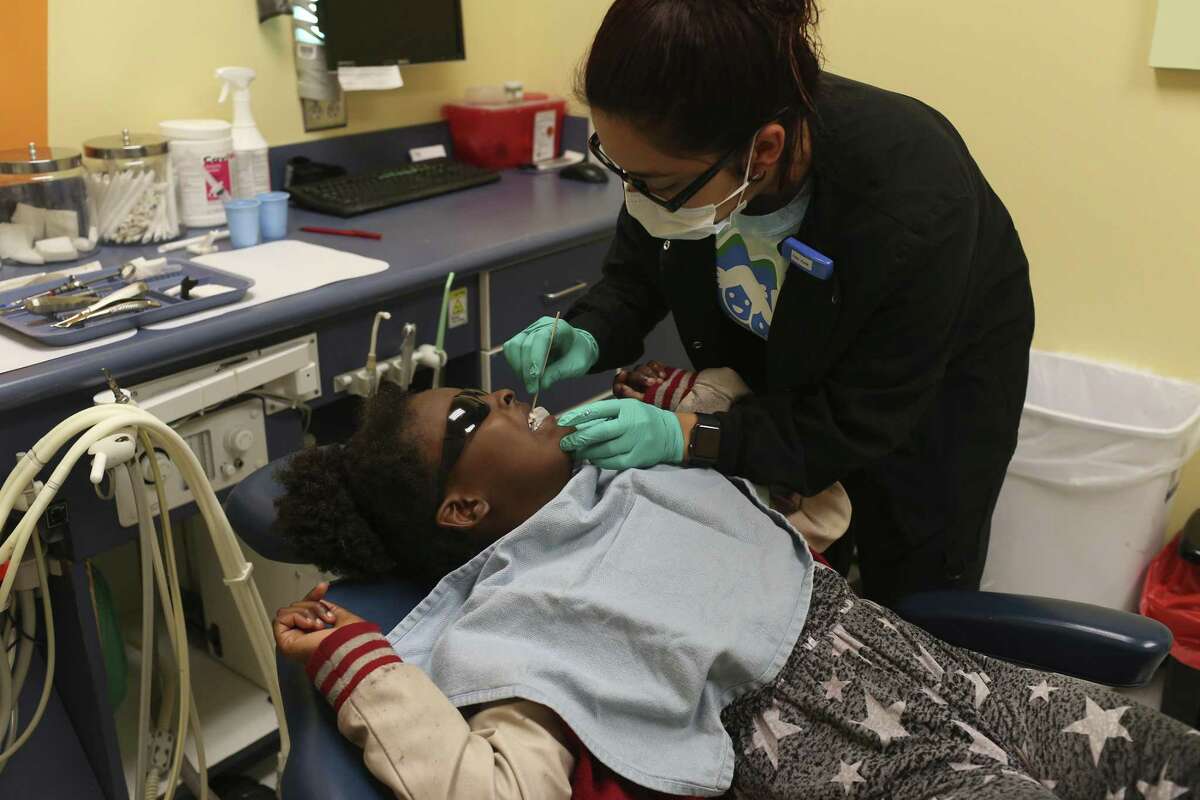 Ruby Ayala prepares Kourtnee Thomas, 8, for an extraction during a free dental clinic at Kool Smiles General Dentistry for Kids, Sunday, May 21, 2017. The services were provided as part of the annual Sharing Smiles Day, offering uninsured and underinsured kids up to 18 free dental exams, extractions, restorative care and emergency care.