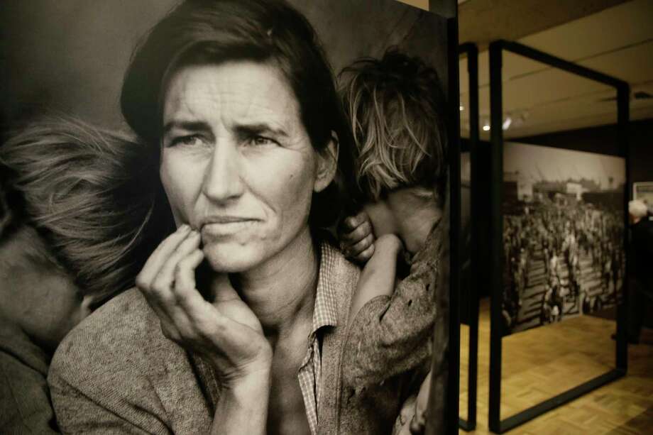 In this photo taken Thursday, May 11, 2017, the iconic photograph Migrant Mother looks out at the exhibit "Dorothea Lange: Politics of Seeing," at the Oakland Museum of California in Oakland, Calif. The three major themes of the Lange display are the Great Depression, the home front during World War II and the urban decline and postwar sprawl in California. Running through August 13, the exhibit includes 100 of Lange's photographs, including recognized works as well as new, improved unframed prints that have been digitally scanned. (AP Photo/Eric Risberg) ORG XMIT: FX501 Photo: Eric Risberg / Copyright 2017 The Associated Press. All rights reserved.