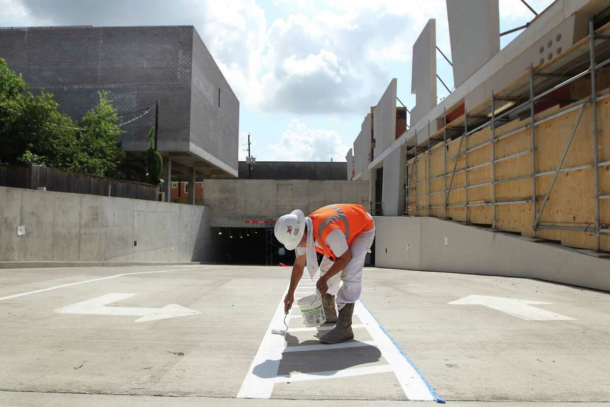 A worker touched up paint along the entry to the new MFAH garage on Saturday.