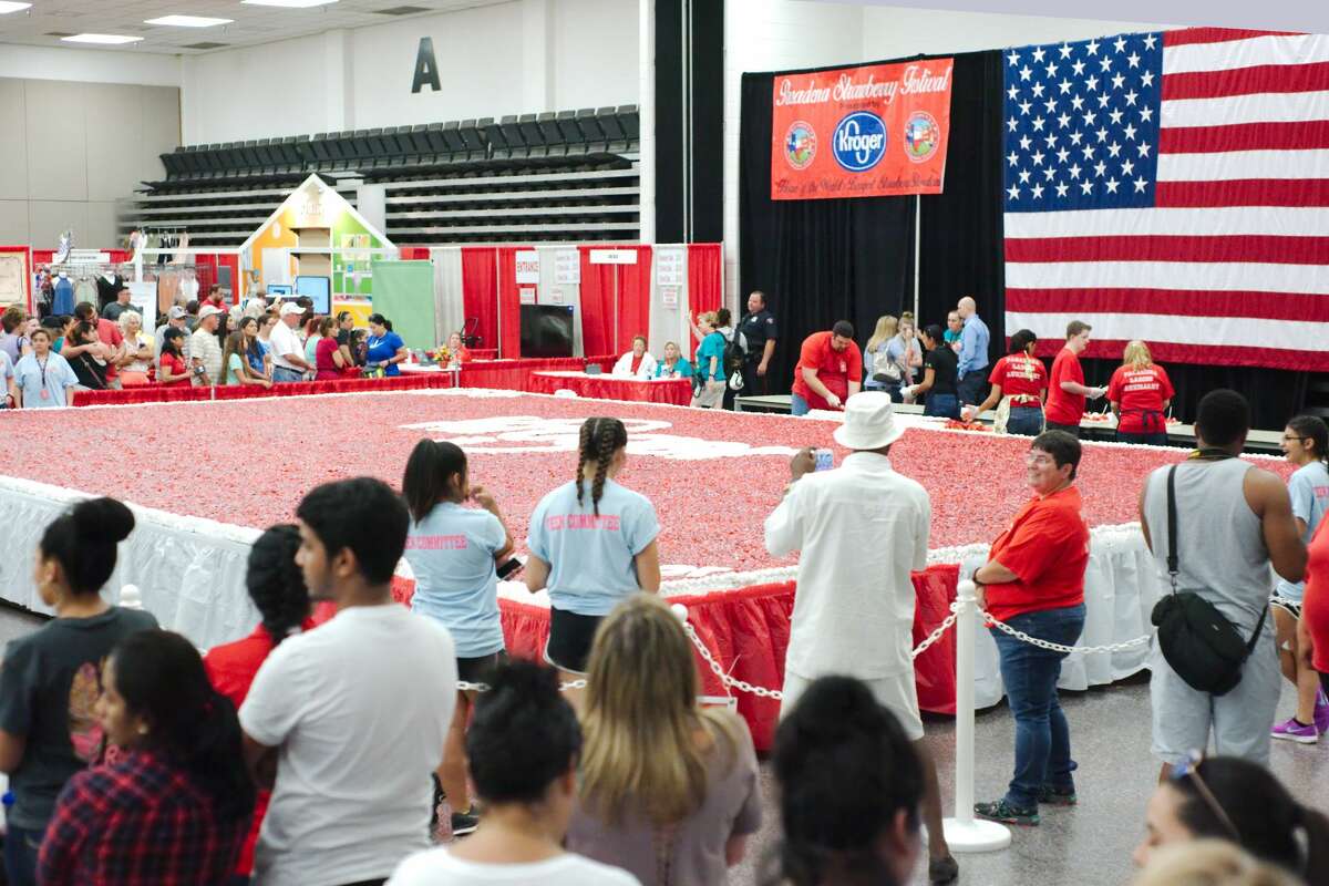 Visitors wait to sample a piece of the world's largest strawberry shortcake at the Pasadena Strawberry Festival Friday, May 19.