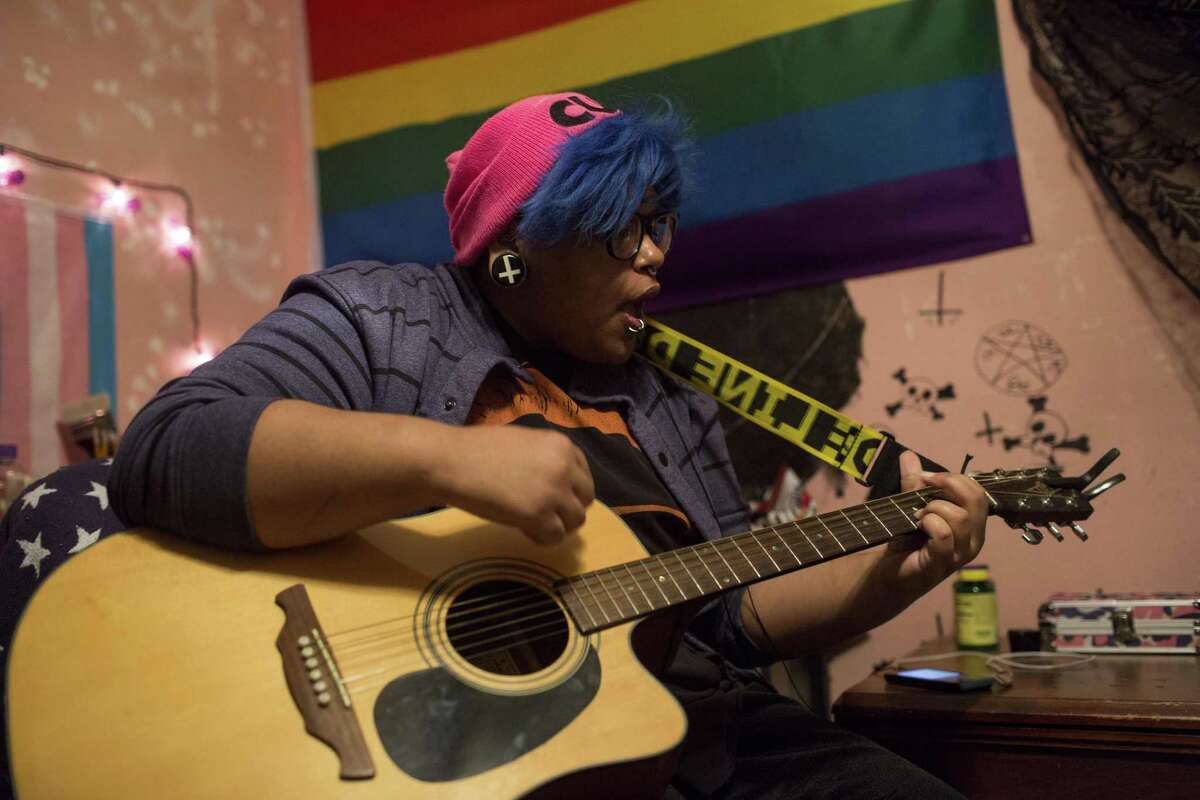 Adam Snow, who is transgender, plays guitar in his bedroom in San Antonio, Texas on February 3, 2017.