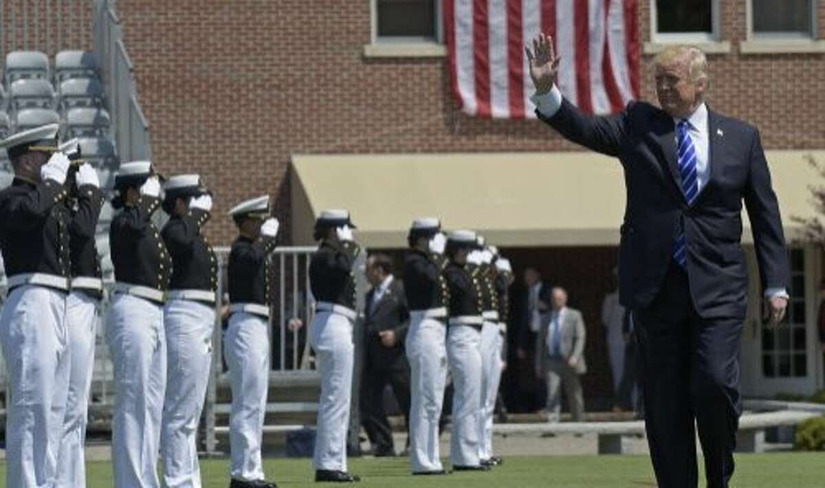 President Donald Trump waves as he arrives to give the commencement address at the U.S. Coast Guard Academy in New London, Conn.