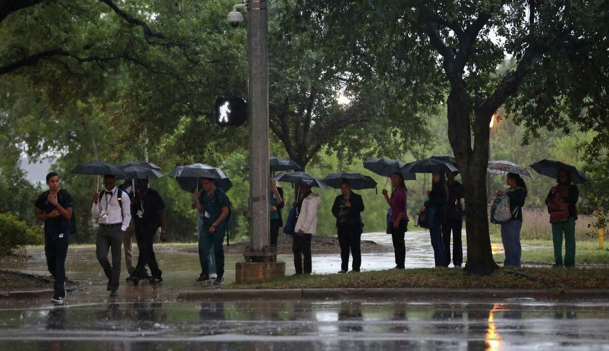 Pedestrians wait to cross the street as rain falls near the Medical Center Monday, May 22, 2017, in Houston. ( Godofredo A. Vasquez / Houston Chronicle )