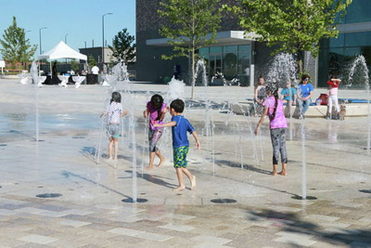 Children play in the fountain in the plaza at the Smart Centre in Sugar Land during May 1 grand opening festivities.