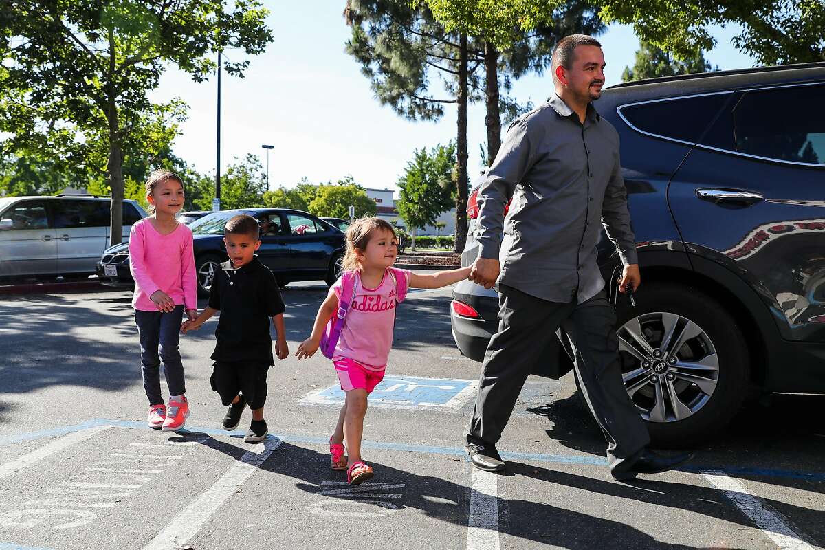 (l-r) Alexia Provencio, 6, Anthony Provencio,4, and Alicia Provencio,3, make their way into Baskin Robbins to get ice cream with their father Michael Provencio in Manteca, California, on Monday, May 22, 2017. Michael fostered Anthony when Anthony was 18-months but has since fully adopted him. Michael was a former foster youth.