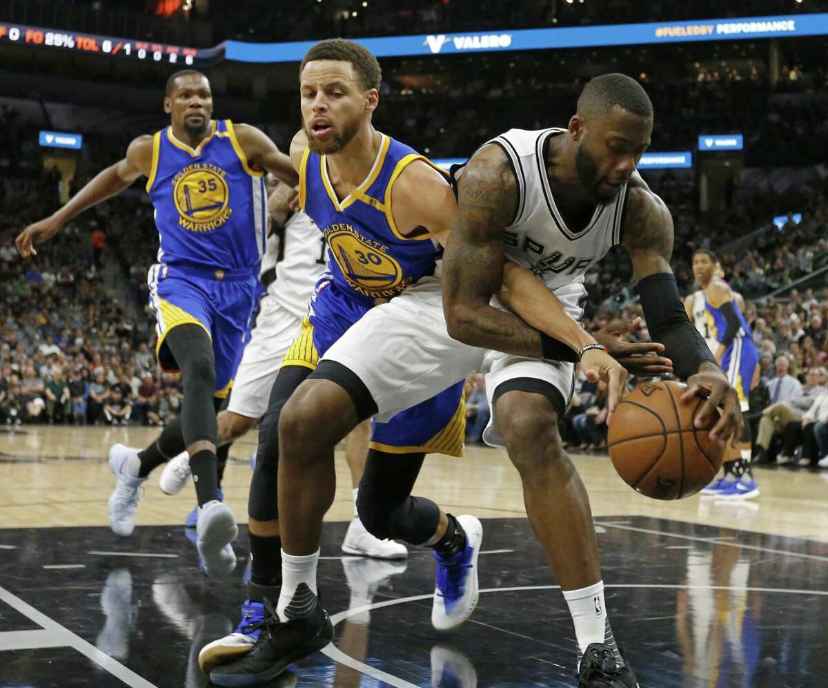 Golden State Warriors’ Stephen Curry and the Spurs’ Jonathon Simmons battle for a loose ball during first half action in Game 4 of the Western Conference finals on May 22, 2017 at the AT&T Center.