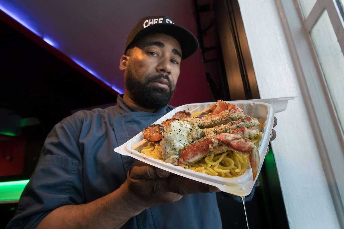 Edward Wooley (Chef Smelly) holds his popular half crab on garlic noodles dish on Friday, May 19, 2017 in Oakland, Calif.