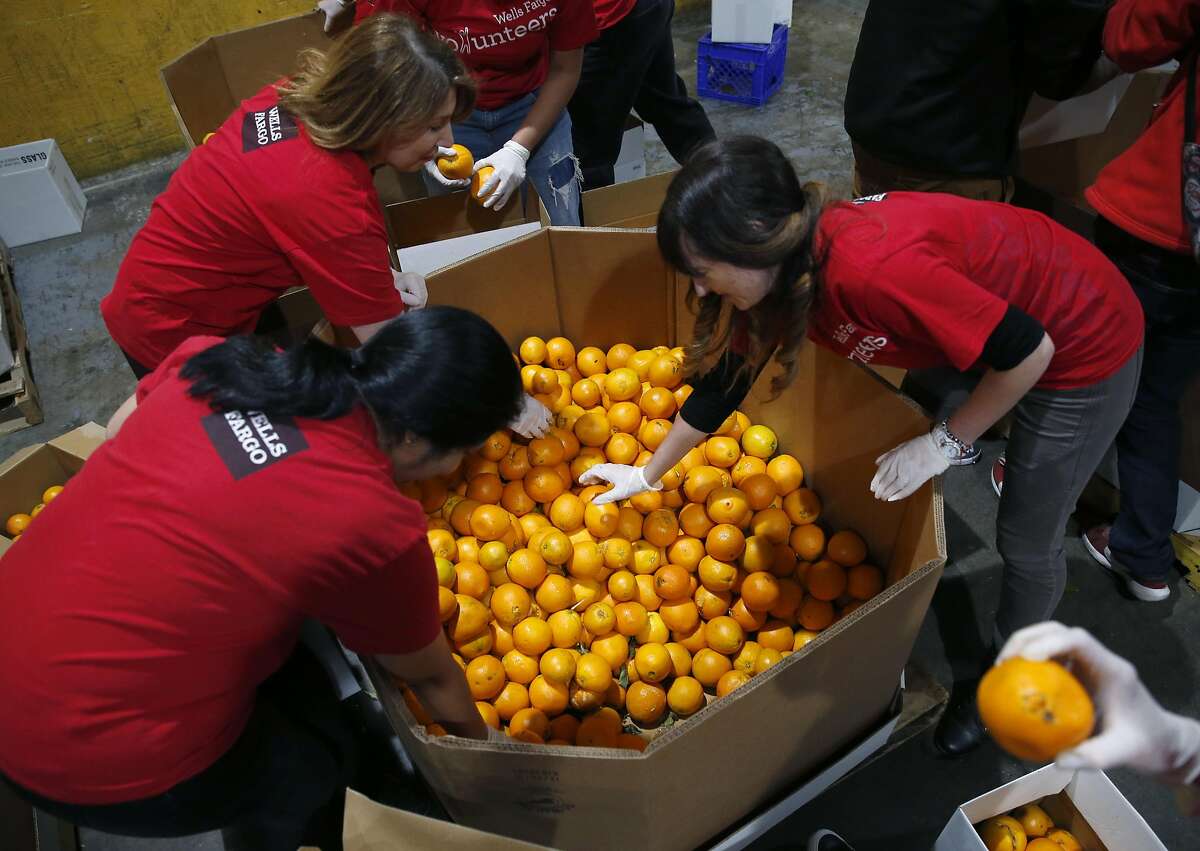 A group of volunteers sort and pack boxes of oranges at the SF-Marin Food Bank in San Francisco, Calif. on Tuesday, May 23, 2017.