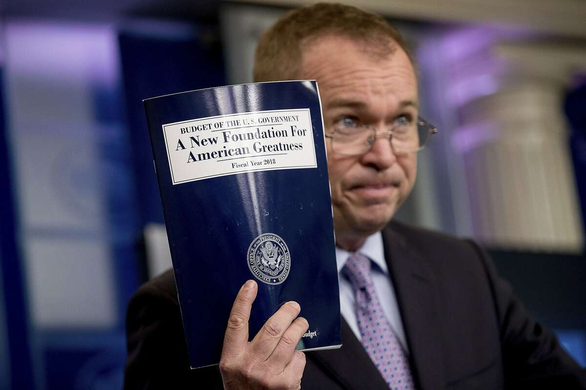 Budget Director Mick Mulvaney holds up a copy of President Donald Trump's proposed fiscal 2018 federal budget as he speaks to members of the media in the Press Briefing Room of the White House in Washington, Tuesday, May 23, 2017. (AP Photo/Andrew Harnik)