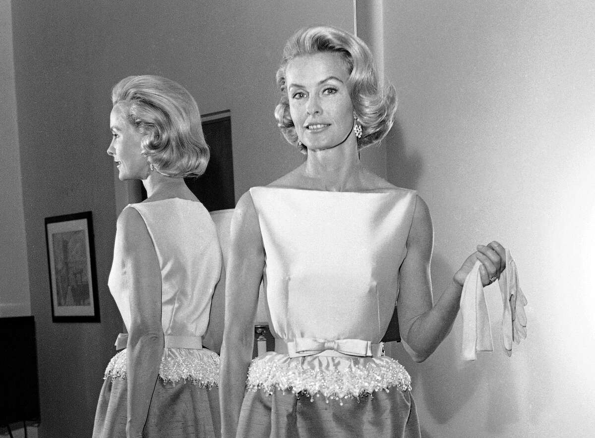 FILE - In this April 6, 1962 file photo, socialite-actress Dina Merrill models the gown she will wear at the Academy Awards presentation in Los Angeles. Merrill, the rebellious heiress who defied her super-rich parents to become an actress, died Monday, May 22, 2017, at age 93. (AP Photo/Harold P. Matosian, File)
