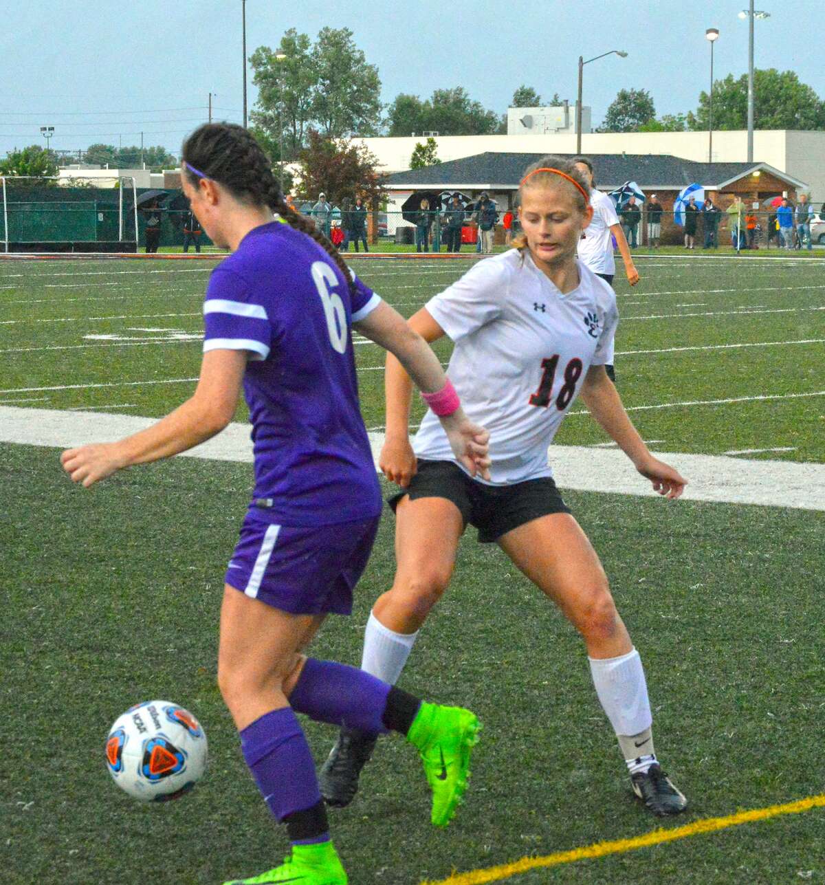 Edwardsville senior forward Abby Crabtree, right, tries to win a loose ball near midfield in the first half.