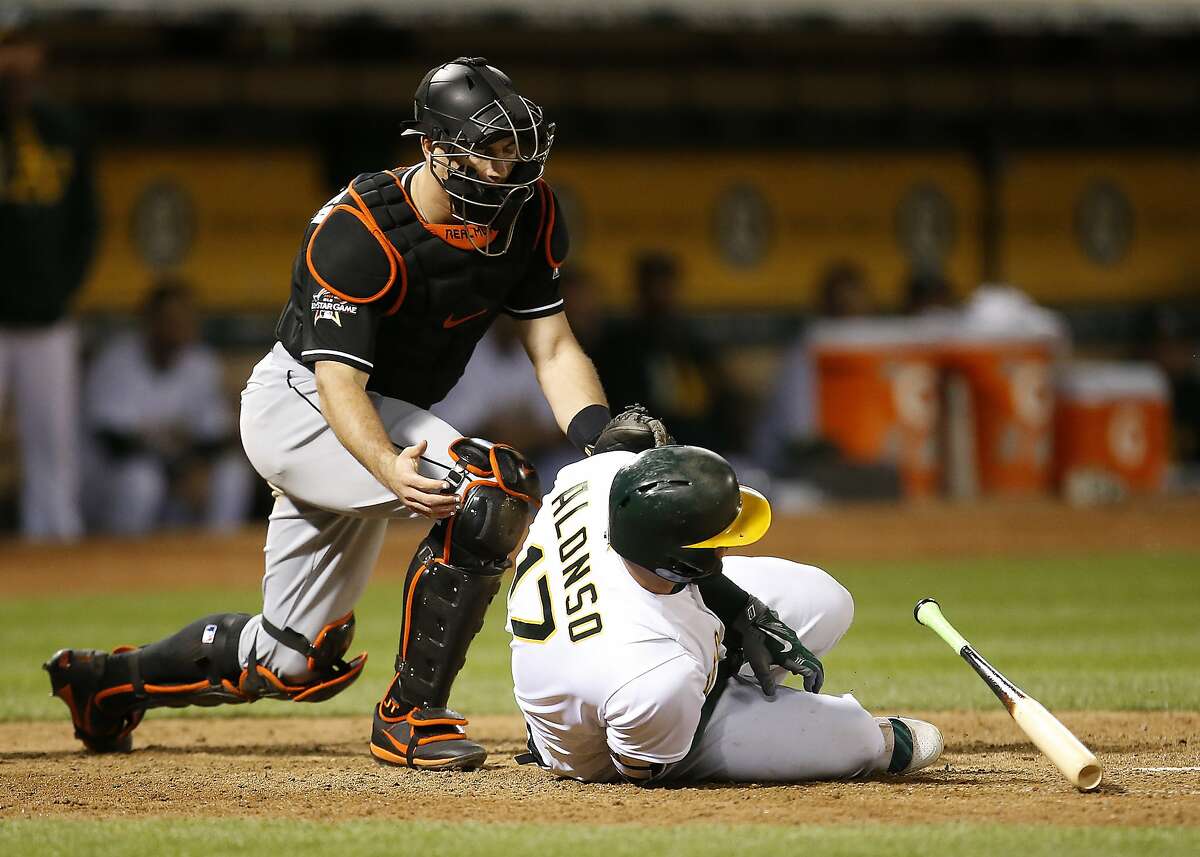Oakland Athletics' Yonder Alonso falls to the ground after being hit by a pitch from Miami Marlins relief pitcher Jarlin Garcia during the sixth inning of a baseball game on Tuesday, May 23, 2017, in Oakland, Calif. (AP Photo/Tony Avelar)