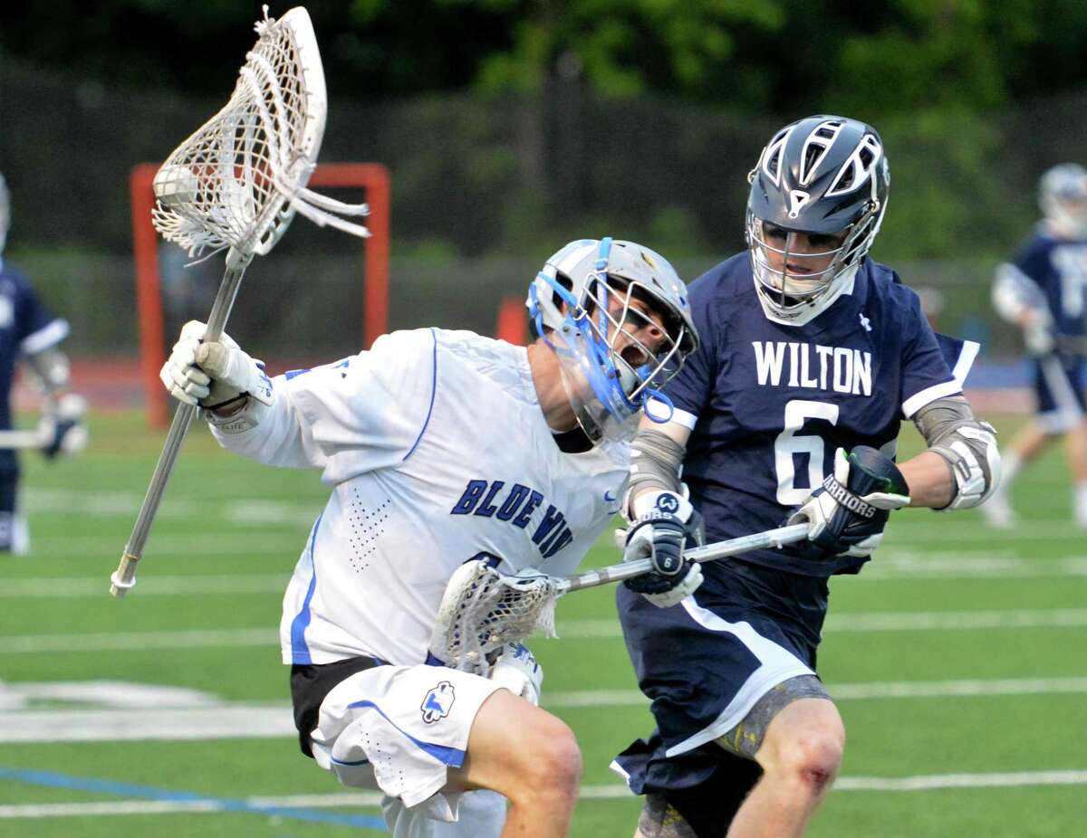 Darien’s Ryan Cornell is defended by Wilton’s Peter Koch as he takes the ball down the field for a shot on goal.
