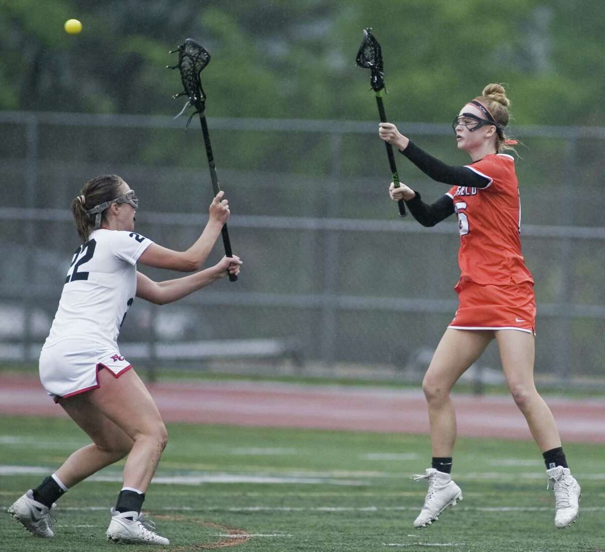 New Canaan High School’s Caroline Schuh tries to block the pass of Ridgefield High School’s Caeleigh Tannian in the FCIAC girls lacrosse semifinals played at Norwalk High School on Monday. Ridgefield upset New Canaan, 14-11.