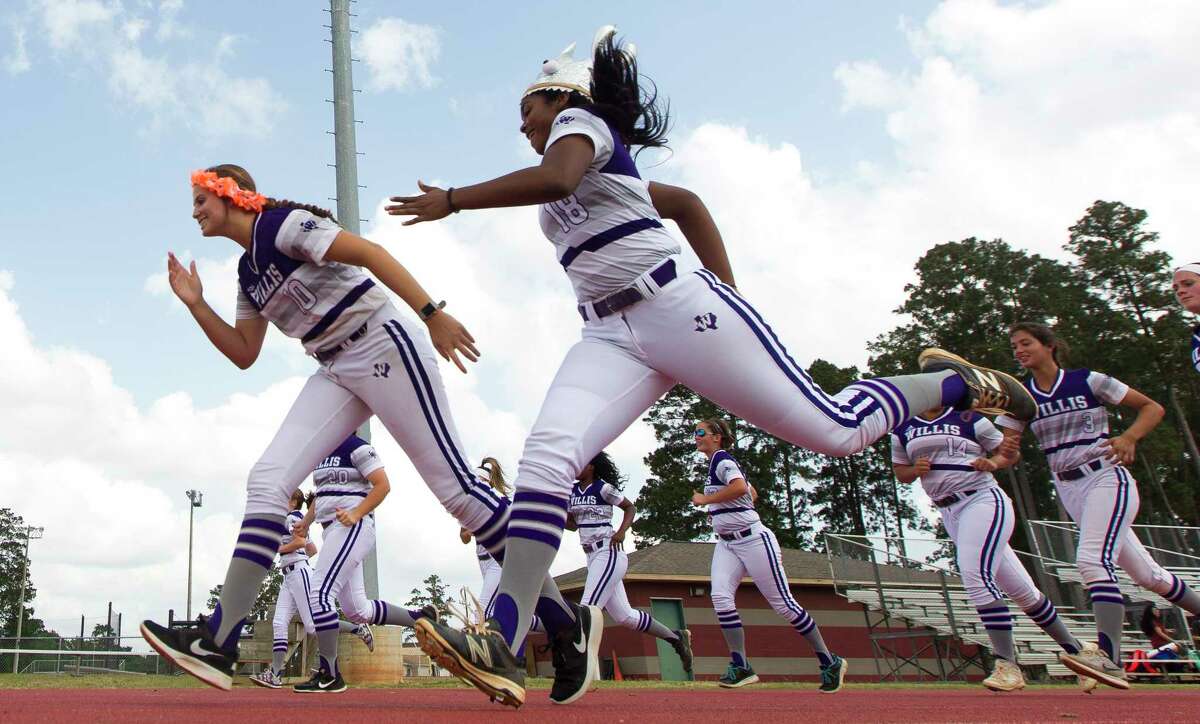 Willis third baseman Samara Lagway, right, races starting pitcher Casey Dixon warms up before Game 2 of a Region III-5A semifinal series Friday, May 19, 2017, in Willis.