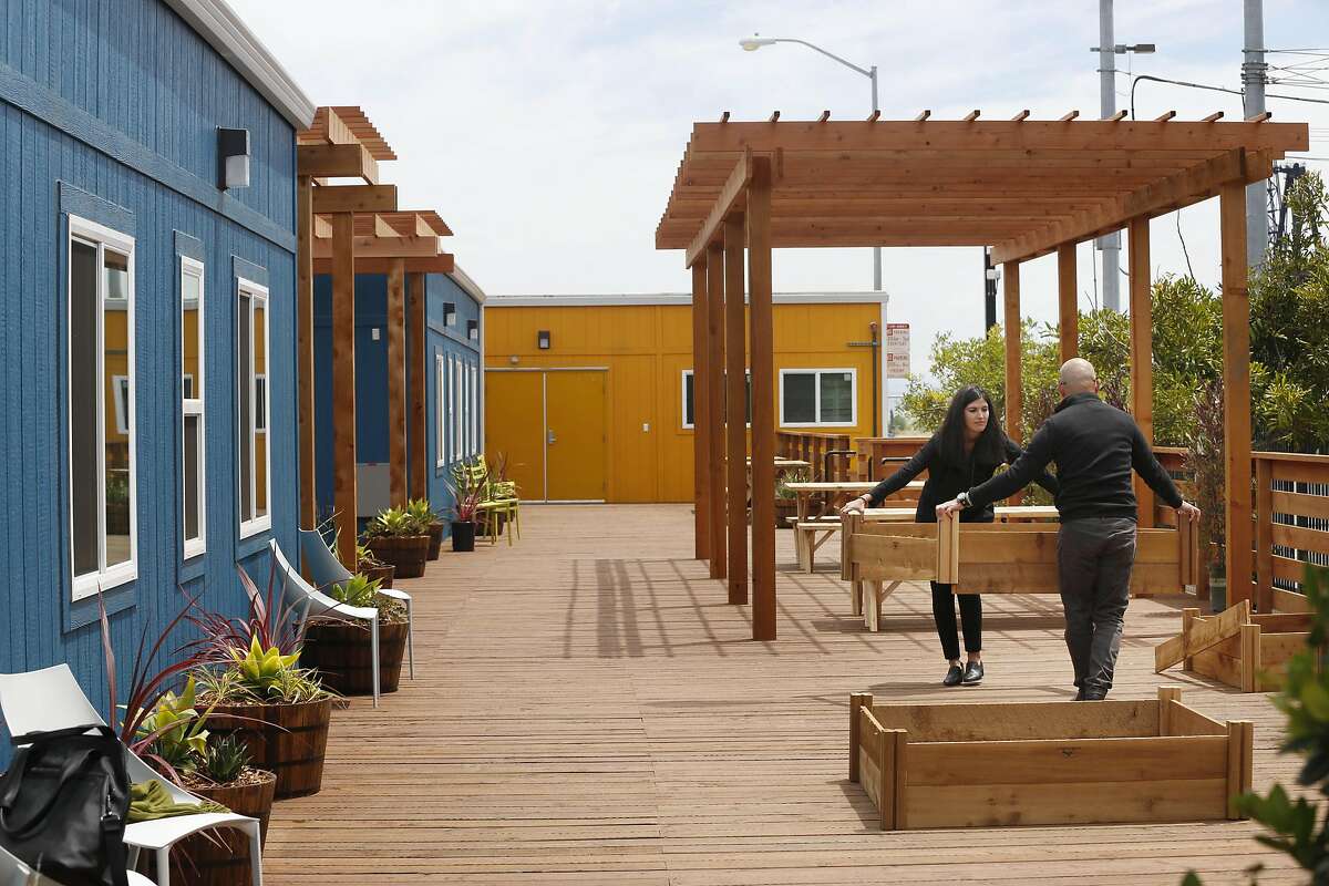 Eoanna Harrison (l to r), San Francisco Department of Public Works, architechtural assistant and Alejandro Pimental, San Francisco Department of Public Works, architechtural associate, set up planters for an edible garden at the Dogpatch Navigation Center on Wednesday, May 24, 2017 in San Francisco, Calif.