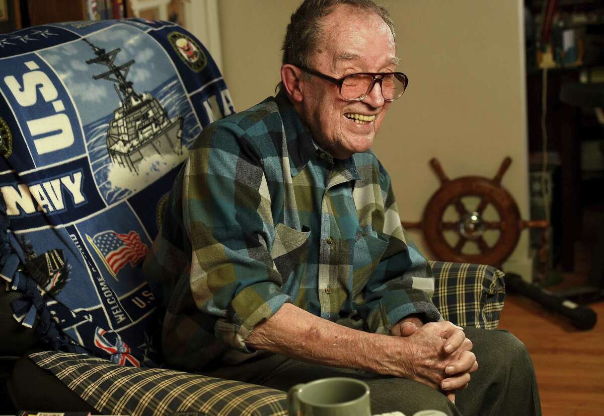 In this November 2014 photo, Lawrence J. Reilly Sr., a U.S. Navy veteran of World War ll and the Vietnam War, sits in the living room of his home in Syracuse, N.Y. He and his 20-year-old son Lawrence J. Reilly Jr. were serving together on U.S. Navy destroyer Frank E. Evans when the ship was cut in half in a collision with the aircraft carrier HMAS Melbourne of the Royal Australian Navy during joint maneuvers in the South China Sea. Seventy-four sailors died but the Pentagon has rejected a longstanding request from survivors of the disaster to add the names of their fallen comrades to the Vietnam Veterans Memorial in Washington, D.C., saying the accident occurred outside the Vietnam combat zone. (Mike Greenlar/Syracuse Post-Standard via AP)