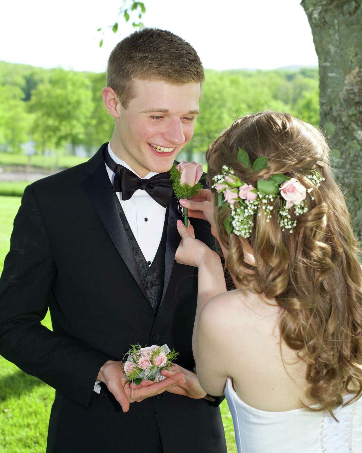 New Milford High School senior Kay Mickelson pins a boutonniere on her escort, sophomore Connor Caridad, before heading to the senior prom held at the Amber Room in Danbury.
