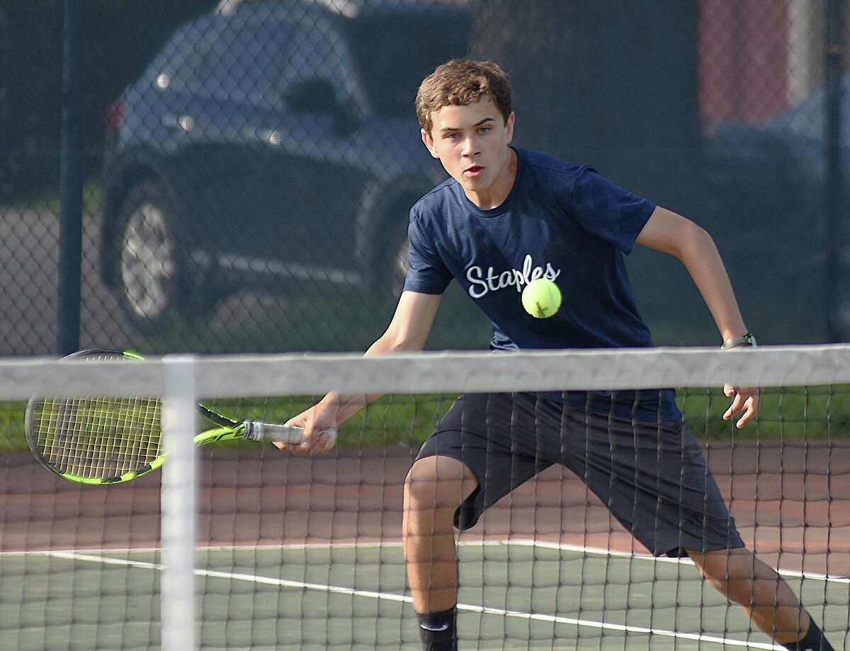 Jack Tooker, a member of the Staples High boys tennis team's seconds doubles squad, keeps his eye on the ball while volleying at the net during Wednesday's FCIAC championship match against New Canaan. Staples won its fourth straight league title with a 4-2 win.