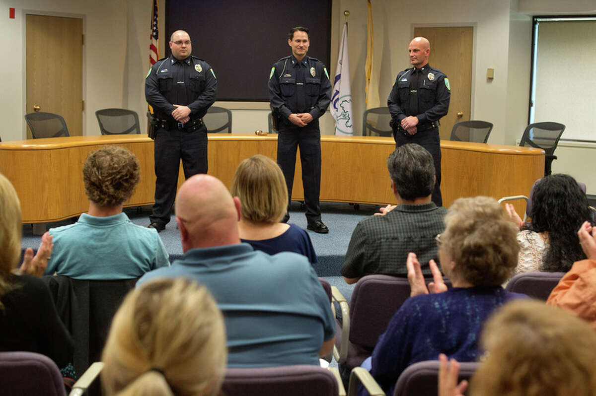 BRITTNEY LOHMILLER | blohmiller@mdn.net People gathered at City Hall applaud newly sworn-in Midland Police Officers Christopher Hurst, Jose DeLeon and James Burchfield II during an officer swearing-in ceremony Wednesday afternoon.