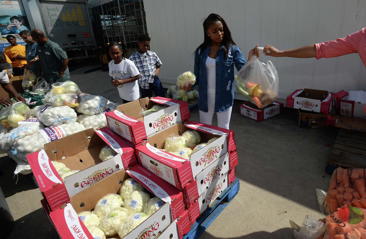 From left, Destiny Jackson, 9, Kennedy Andrews, 12 and Kendriana Andrews, 14, sack produce during the Southeast Texas Food Bank's drive on Tuesday. Senior citizens also registered for monthly food distributions in the Senior Box program. Photo taken Tuesday, May 24, 2017 Guiseppe Barranco/The Enterprise