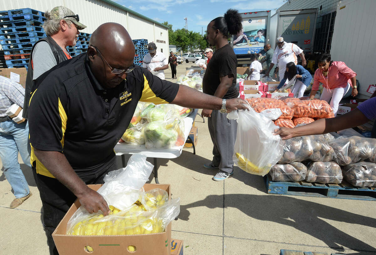 Melvin Brock sacks produce during the Southeast Texas Food Bank's drive on Tuesday. Senior citizens also registered for monthly food distributions in the Senior Box program. Photo taken Tuesday, May 24, 2017 Guiseppe Barranco/The Enterprise