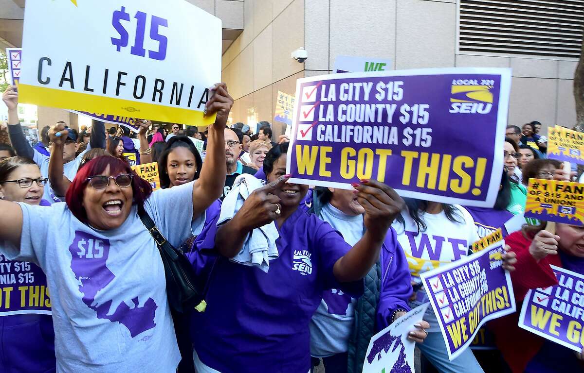 Workers celebrate outside the Ronald Reagan State Building in downtown Los Angeles, where California Governor Jerry Brown signed the bill that will raise the state's minimum wage to $15 an hour by 2022 while surrounded by supporters and politicians in Los Angeles, California on April 4, 2016. / AFP PHOTO / FREDERIC J. BROWNFREDERIC J. BROWN/AFP/Getty Images