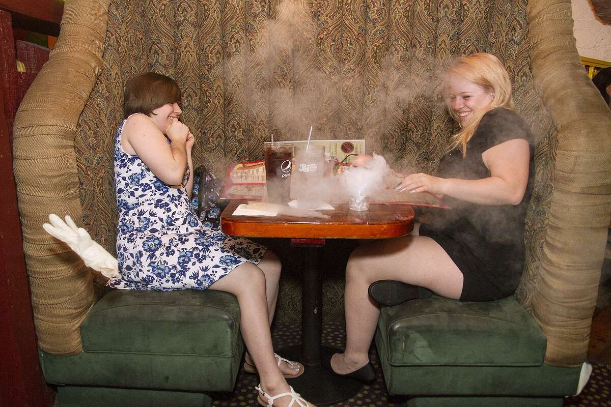 Tanya Menard (left) and Brianna Rouse react to a smoke “bomb” going off on their table.