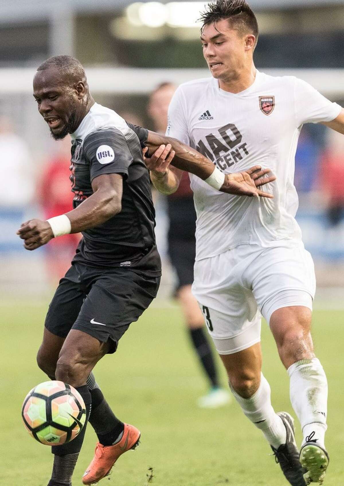 San Antonio FC’s Billy Forbes (left) takes on Phoenix Rising FC defender Eder Arreola on May 20, 2017, at Toyota Field.