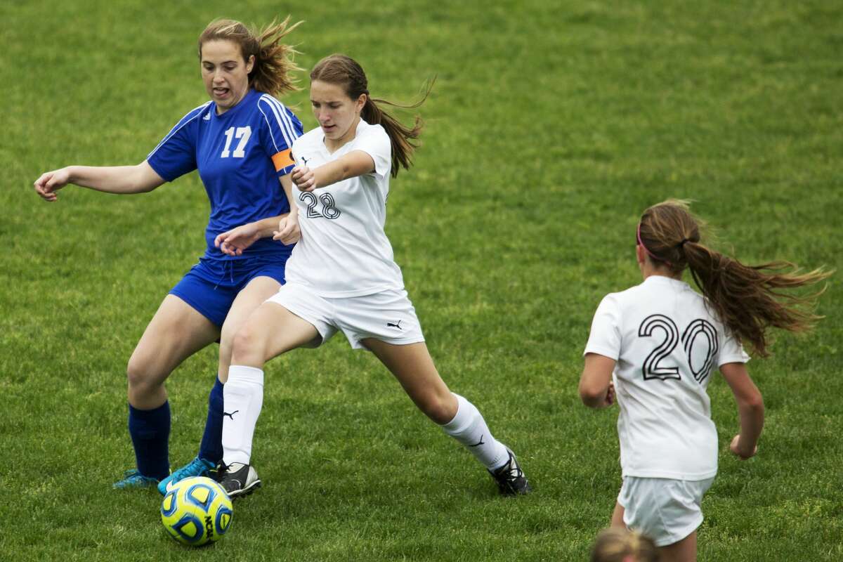 Oscoda's Kaleigh Vollmers and Bullock Creek's Emma Fransen fight for possession of the ball in a game at Bullock Creek High School on Thursday.