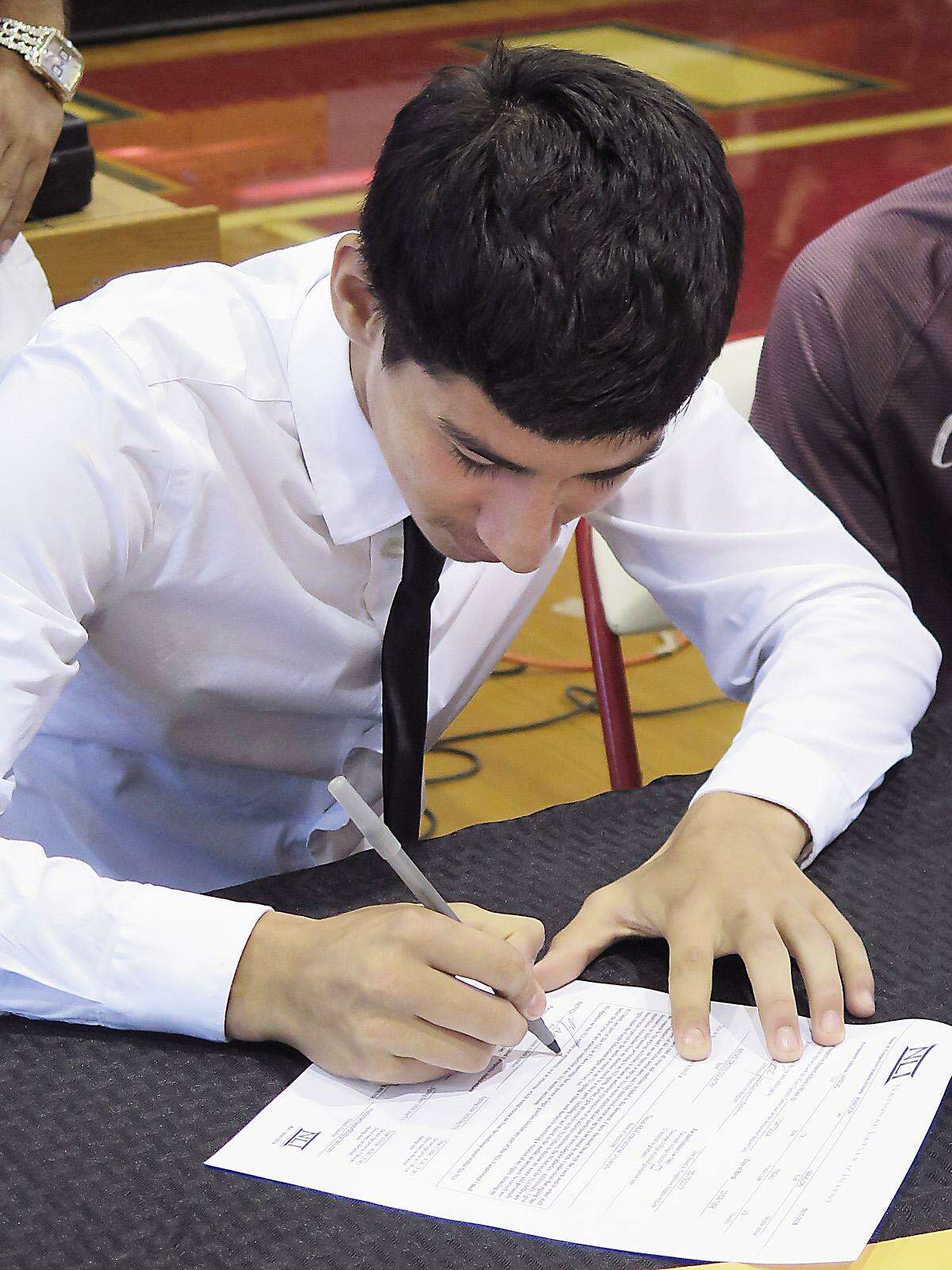 Martin High School athlete Marlon Amador signs his letter of intent to run for TAMIU.