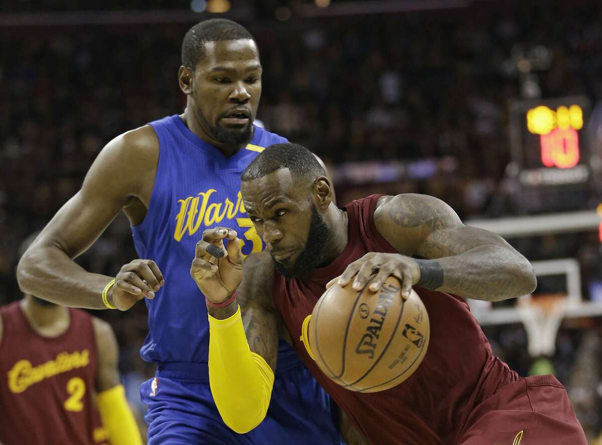 FILE - In this Dec. 25, 2016, file photo, Cleveland Cavaliers' LeBron James drives against Golden State Warriors' Kevin Durant during an NBA basketball game in Cleveland. Now, as James, Durant and their teammates wait on the next opponent for the respective conference finals, the world is watching as they move their unblemished, 8-0 teams ever closer to an anticipated Cavs-Warriors rematch that might finally come to fruition at last in a matter of weeks. (AP Photo/Tony Dejak, File)