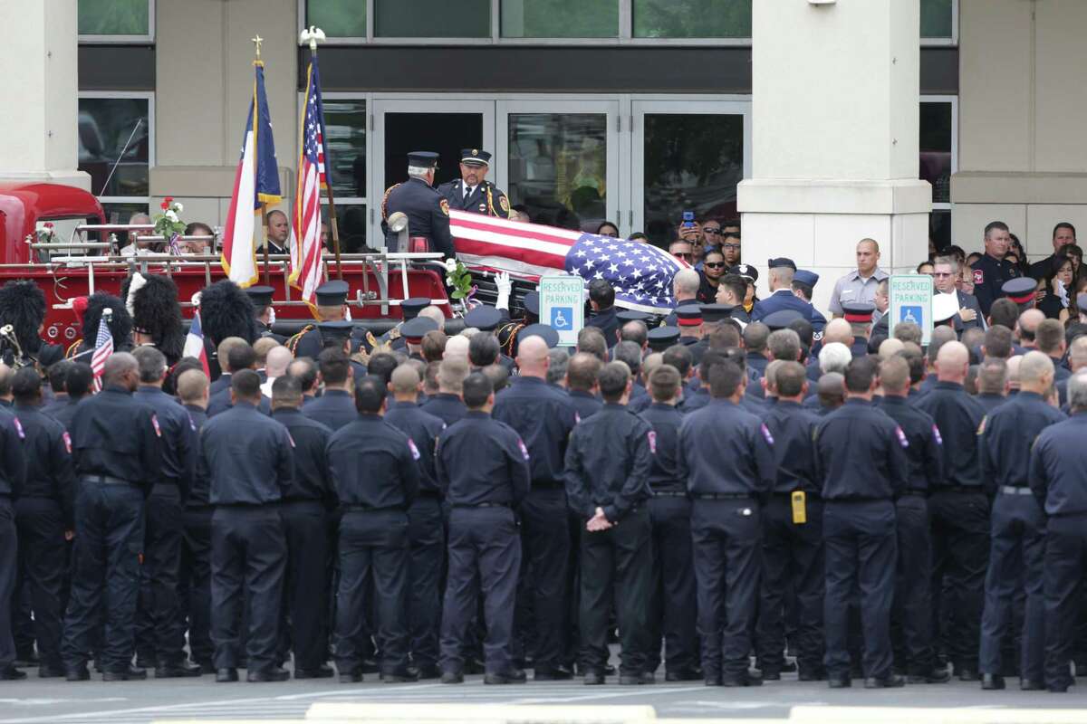 Firefighters salute as the body of a fallen firefighter arrives at Community Bible Church for the funeral for firefighter Scott Deem, who was killed May 18 fighting a blaze in a Northwest Side gym, on Friday, May 26, 2017.