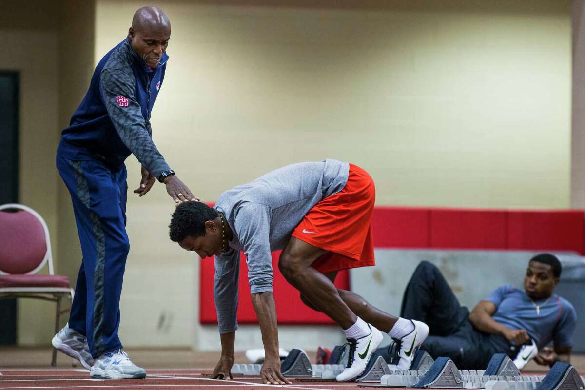 Carl Lewis works with Jermaine Fyffe on his starts during practice at the University of Houston indoor track on Wednesday, Feb. 18, 2015, in Houston. The former UH track star and nine time Olympic gold medalist has joined the Cougars' track and field program as an assistant coach, and will help with sprints and jumps.( Brett Coomer / Houston Chronicle )