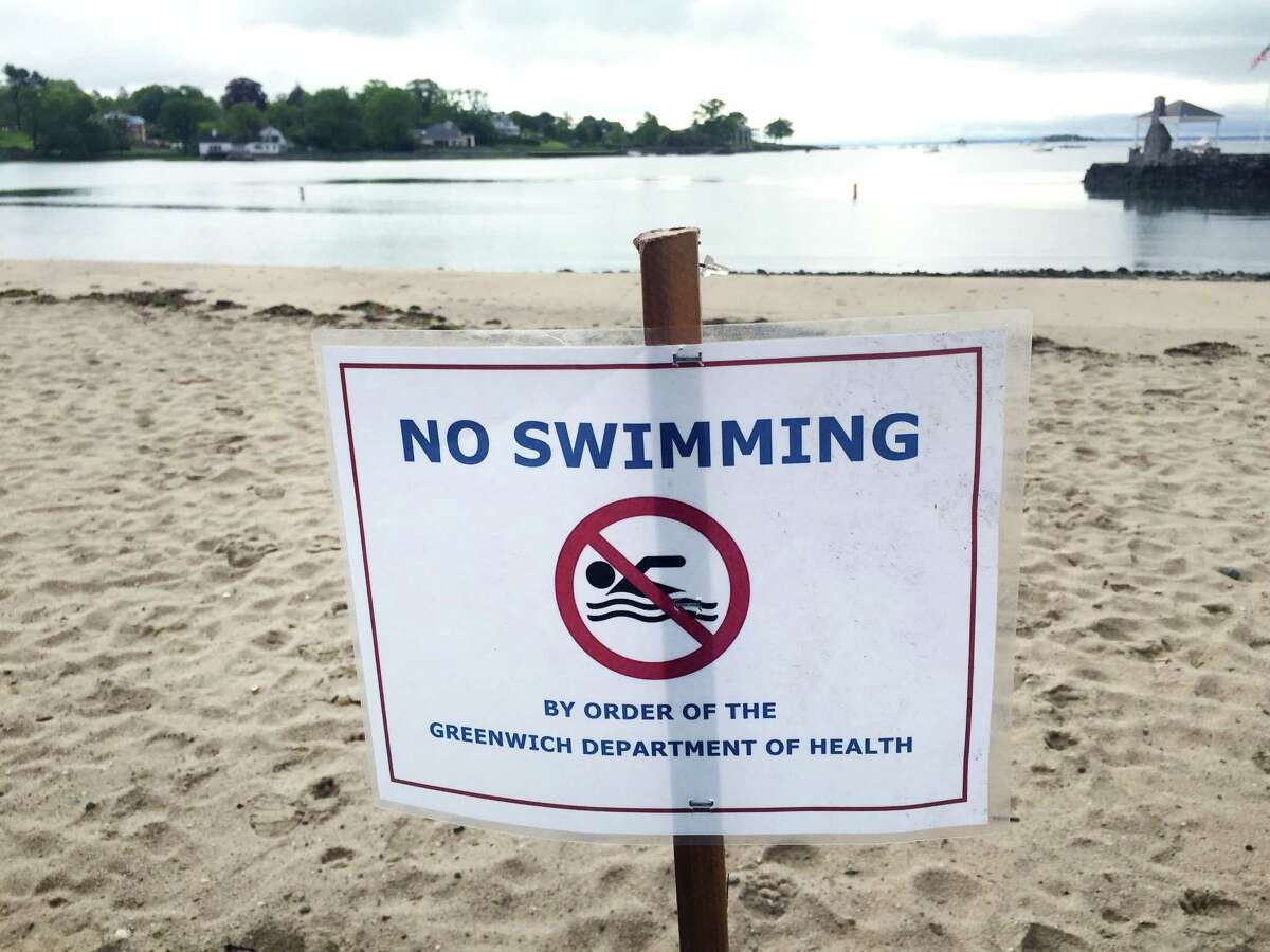 A "No Swimming" sign that also reads "by order of Greenwich Department of Health," can be seen on Byram Beach in Greenwich, Conn., Friday morning, May 27, 2017. Beach season officially begins Saturday.