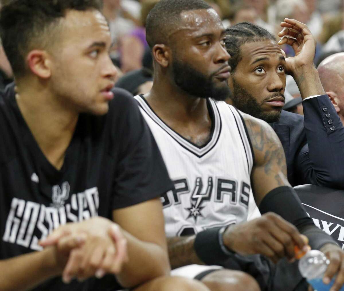 Spurs’ Kawhi Leonard sits behind the bench near teammates Kyle Anderson (left) and Jonathon Simmons during a timeout in first half action of Game 3 in the Western Conference finals against the Golden State Warriors on May 20, 2017 at the AT&T Center.
