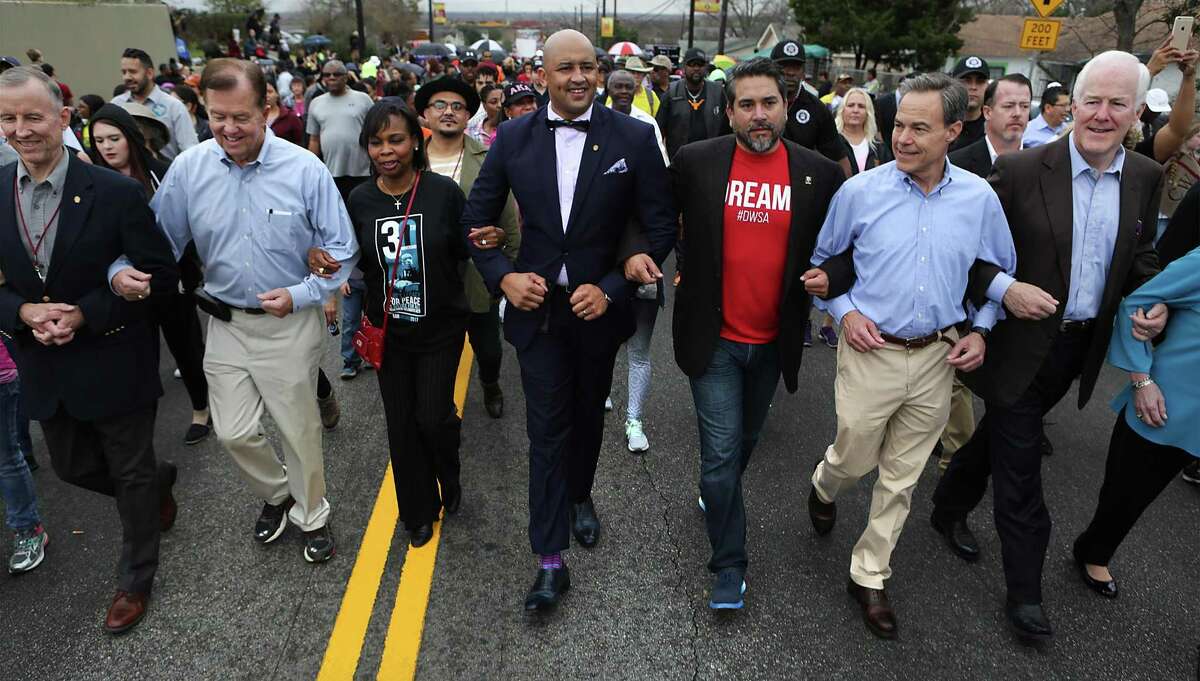 The dignitary line including Councilman Mike Gallagher, Councilman Joe Krier, Mayor Ivy Taylor, Councilman Alan Warrick II, Councilman Roberto Trevino, TX Speaker of the House Joe Straus, and U.S. Senator John Cornyn walk arm in arm at the 30th San Antonio Martin Luther King Jr March on Monday, Jan. 16, 2017.