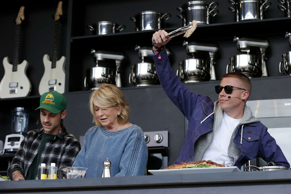 From right: Macklemore holds a piece of chicken as he cooks with Martha Stewart and Ryan Lewis during BottleRock.