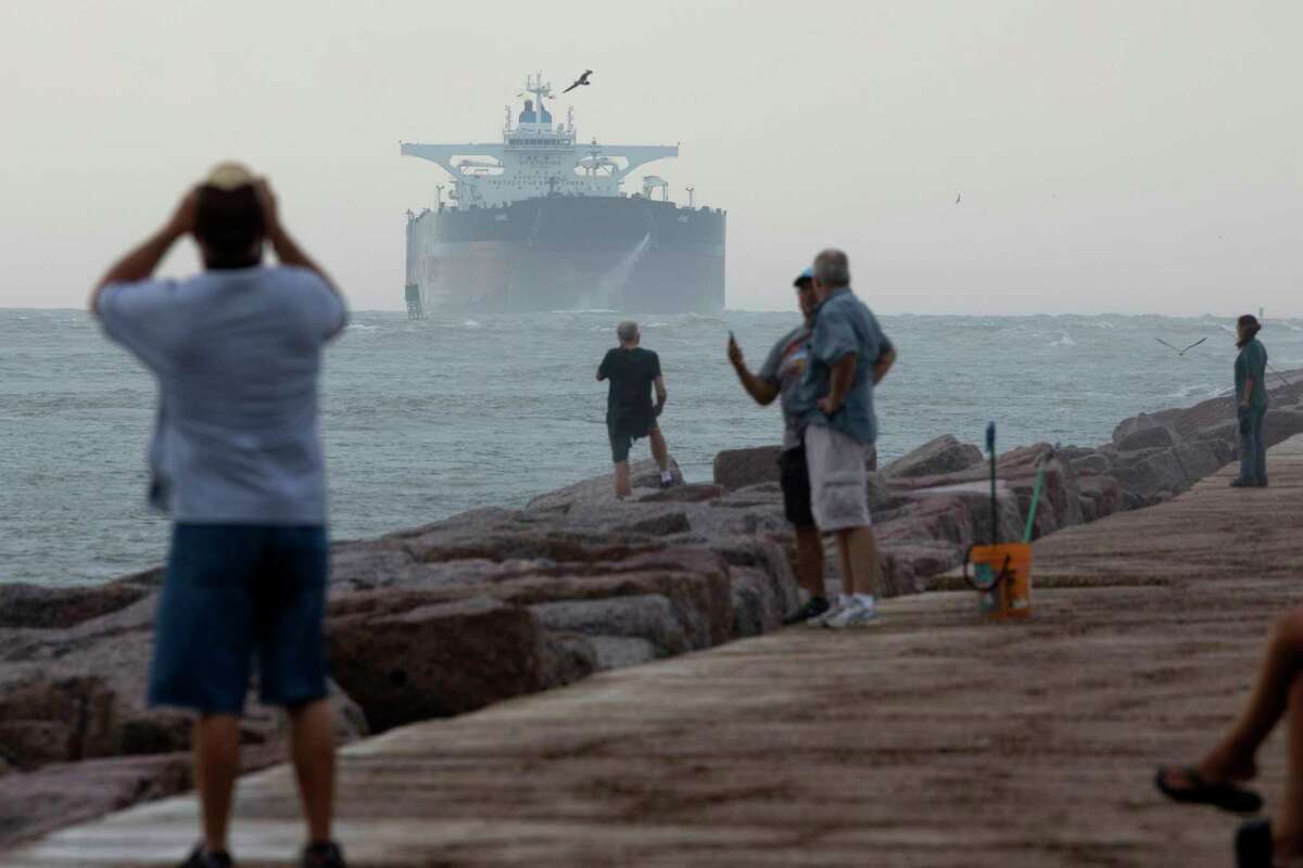 Spectators watch as the largest tanker to dock in a Gulf of Mexico port approaches the Port of Corpus Christi shipping channel in Port Aransas, Texas, on Friday, May 26, 2017. (Courtney Sacco/Corpus Christi Caller-Times via AP)
