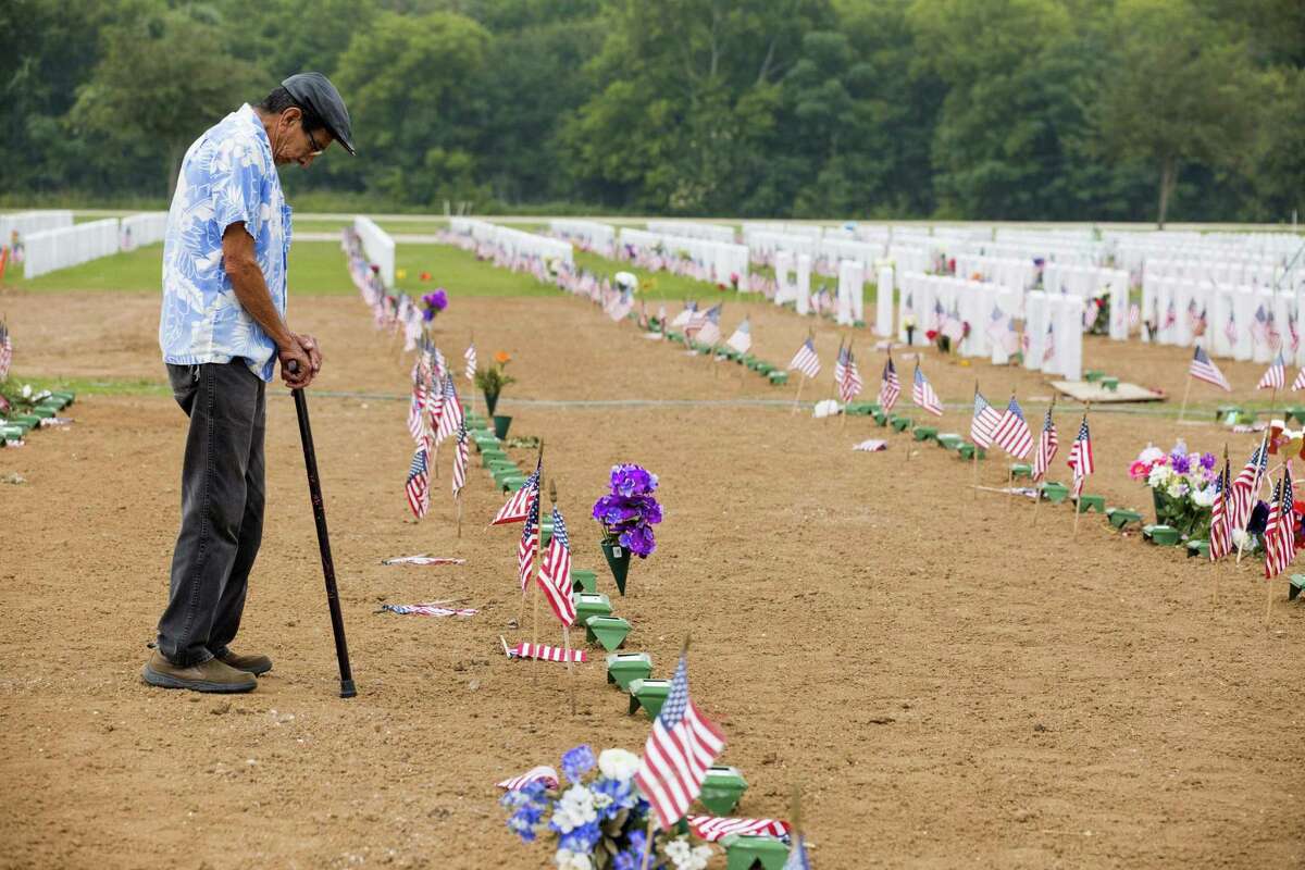 Phillip Suarez, a Marine Corps veteran, pays his respects to his brother-in-law Genaro Rincon in the section of Fort Sam Houston National Cemetery where recently deceased veterans are interred. Rincon, who was interred May 9, was one of the more than 2400 names the American Legion read aloud at Fort Sam Houston National Cemetery in San Antonio, Texas on May 27, 2017. Ray Whitehouse / for the San Antonio Express-News