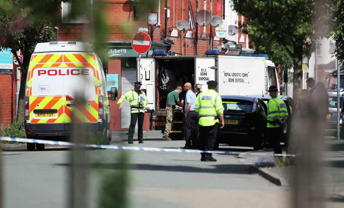 An army bomb disposal team works with members of the police in the Moss Side area of Manchester, England, Saturday, May 27, 2017. British police say they are evacuating residents around a house being searched in connection with the Manchester concert bombing. Police are searching a number of properties and have 11 suspects in custody in connection with Monday's explosion at an Ariana Grande concert in Manchester, which killed more than 20 people and injured dozens. (Jonathan Brady/PA via AP)