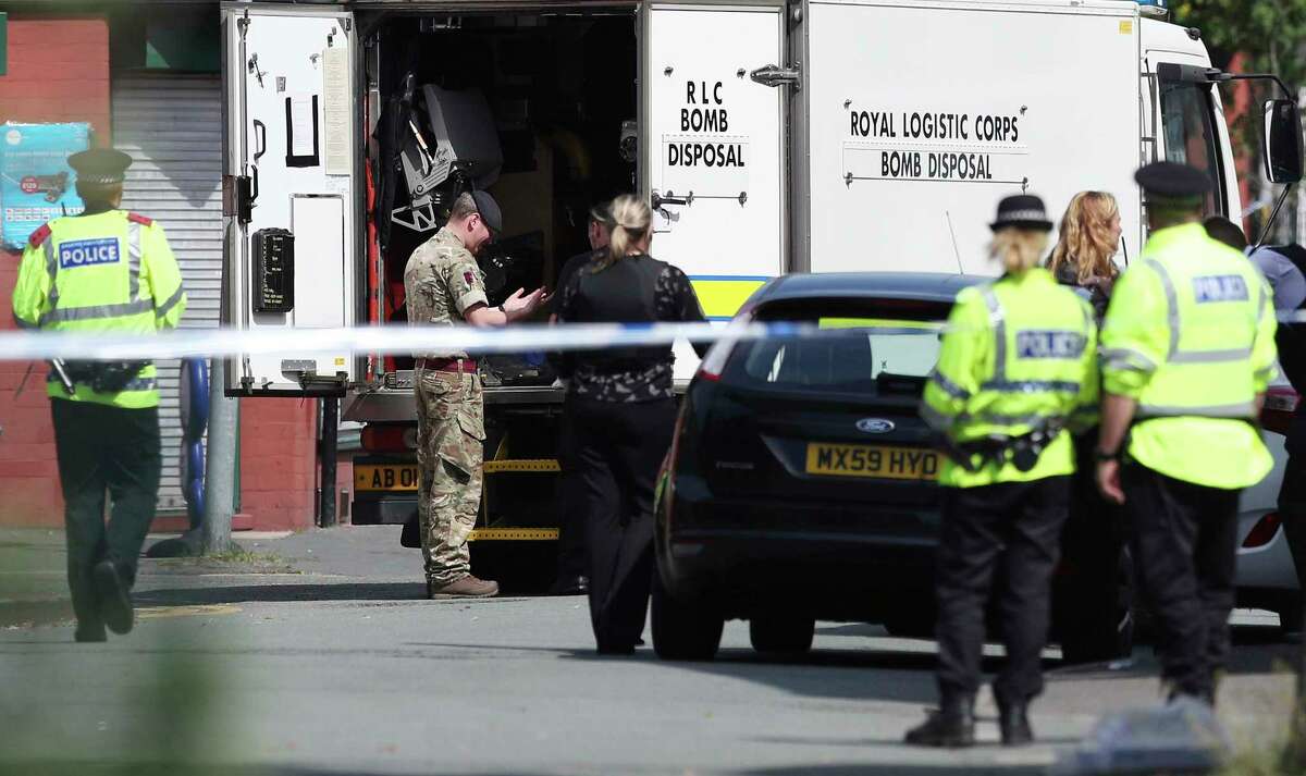 An army bomb disposal team works with members of the police in the Moss Side area of Manchester, England, Saturday, May 27, 2017. British police say they are evacuating residents around a house being searched in connection with the Manchester concert bombing. Police are searching a number of properties and have 11 suspects in custody in connection with Monday's explosion at an Ariana Grande concert in Manchester, which killed more than 20 people and injured dozens. (Jonathan Brady/PA via AP)