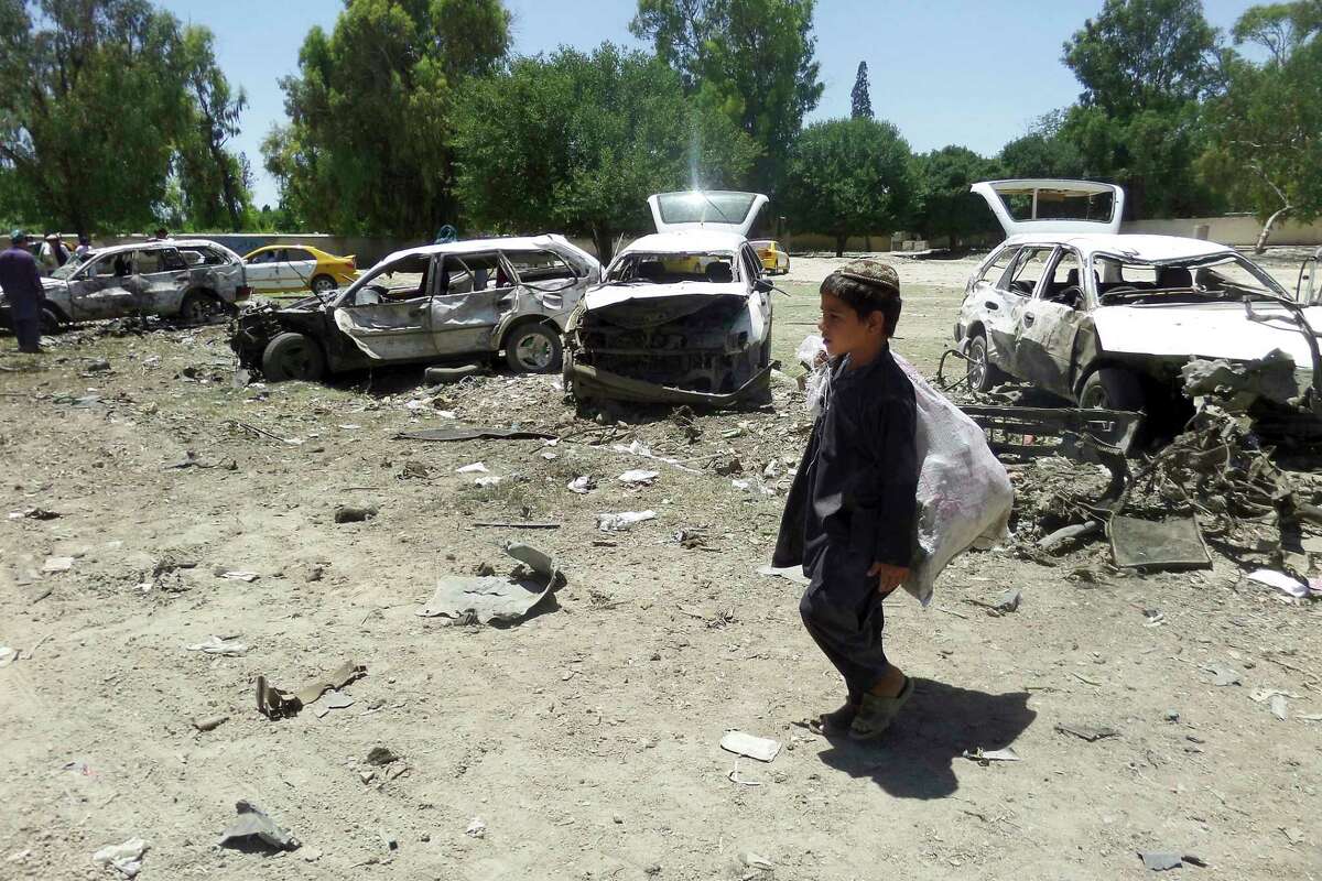 A boy walks passed damaged vehicles at the site of a suicide attack in eastern Khost province, Afghanistan, Saturday, May 27, 2017. At least 18 people, mostly civilians, were killed Saturday when a suicide car bomber targeted a convoy of provincial security forces in eastern Afghanistan, an Interior Ministry official said. (AP Photos/Nishanuddin Khan)