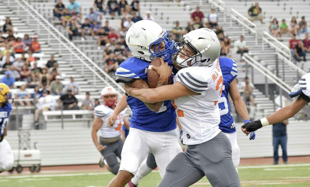 East All-Stars quarterback Antonio De La Torre is brought down by Isaac Hernandez from the West All-Stars. De La Torre represented Cigarroa going 5 of 11 for 46 yards with a touchdown and an interception.